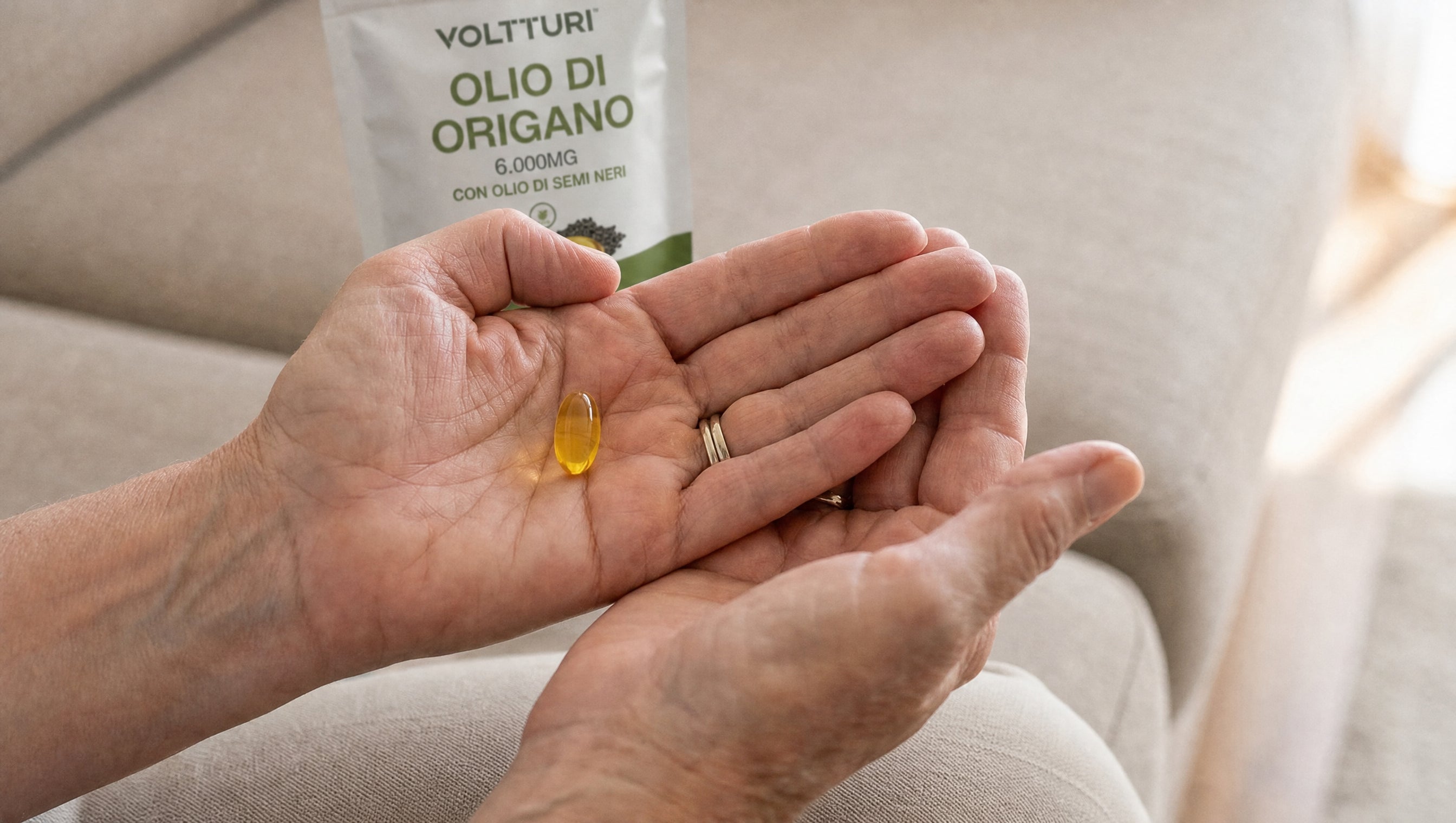 Una capsula di Voltturi Olio di Origano nel palmo della mano